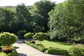 A paved pathway leading through a landscaped garden with neatly trimmed hedges and trees. - Holiday apartment with 1 bedroom (Quedlinburg \/ OT Bad Suderode)