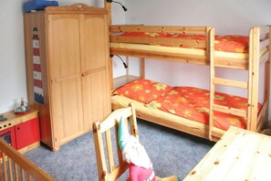 A bunk bed with a wooden headboard and a small table. - Holiday home with 3 bedrooms (Nordstrand)