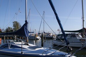 A marina with multiple boats docked, featuring masts and rigging. - Holiday apartment in Born with sauna (Born)
