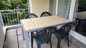 A balcony with a table and chairs, a railing, and a view of greenery. - Apartment 'Zinnowitz, Dünenstraße WE 15' with Balcony and Wi-Fi (Zinnowitz)