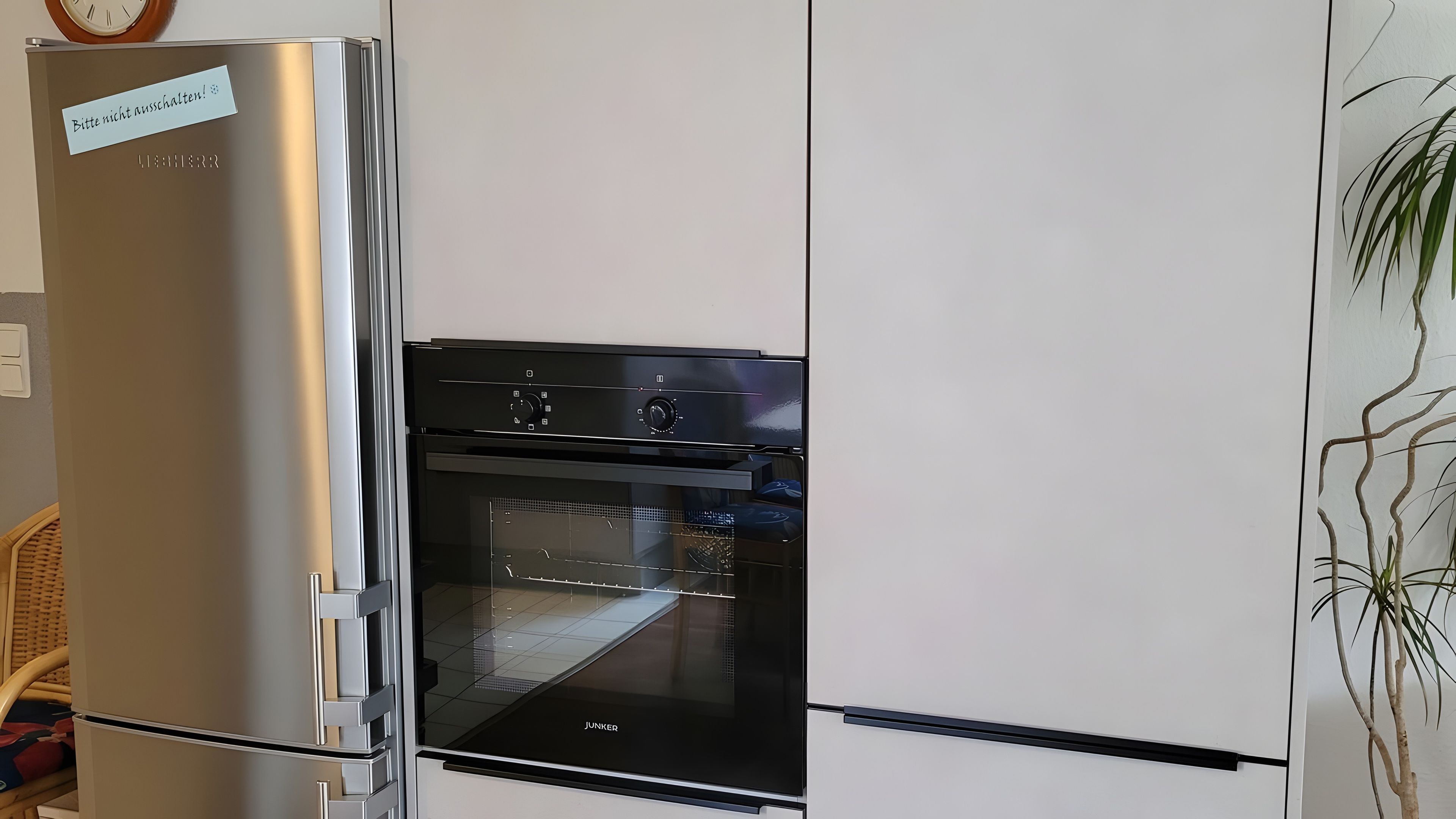 Una cocina con un refrigerador de acero inoxidable y un horno negro.