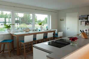 Una cocina moderna con comedor, ventanas amplias y vistas al exterior.