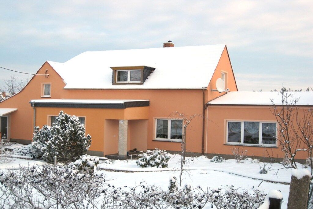 A two-story house with a sloped roof, a small attic window, and a front porch.