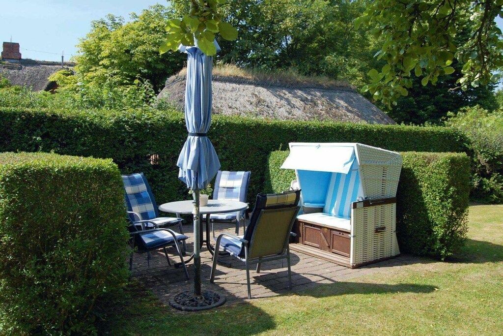 An outdoor seating area with a table, chairs, and a covered umbrella.