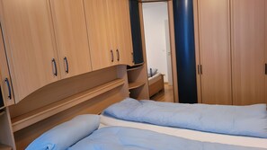Ein Schlafzimmer mit einem Bett, einem Holzschrank und einem kleinen Nachttisch.