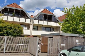 Ein zweigeschossiges Gebäude mit flachem Dach und einem Balkon im oberen Stockwerk.