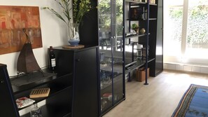 A modern interior with a black bookshelf, a wine bottle, and a vase with plants. - Apartment 'Zinnowitz, Dünenstraße WE 3' with private terrace and Wi-Fi (Zinnowitz)