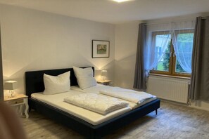 A bedroom with a large bed, two bedside tables with lamps, a window with curtains, and a framed picture on the wall. - ||-----------------------Rhododendron EG----------------|| (Prerow)