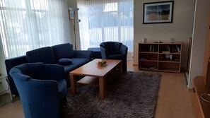 A living room with a sofa, armchairs, a coffee table, and a bookshelf. - Apartment 'Zinnowitz, Dünenstraße WE 20' – close to the beach, terrace, pets allowed (Zinnowitz)