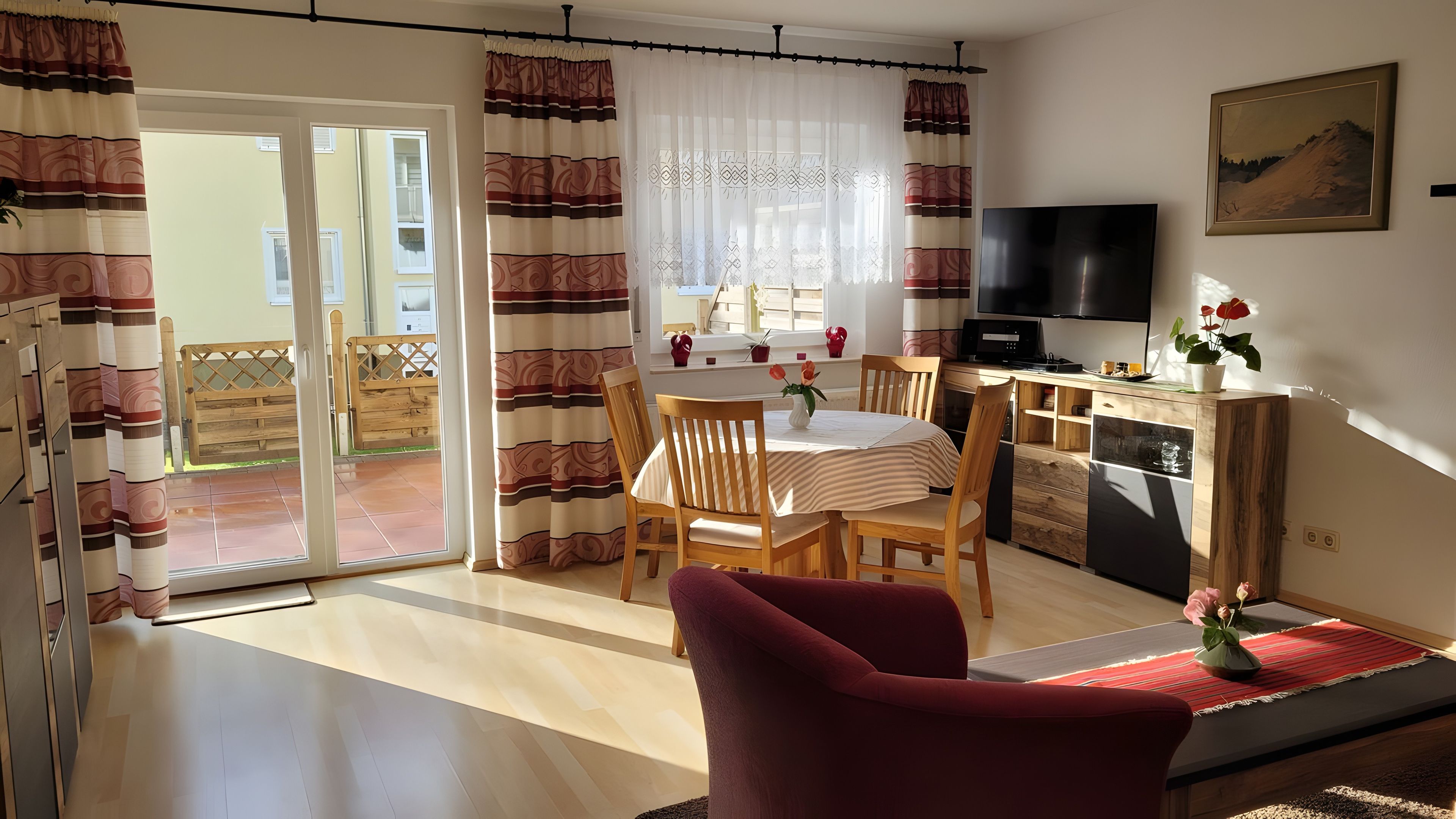 Ein Wohnzimmer mit Essbereich, einem Fernseher und einer Küchenzeile.