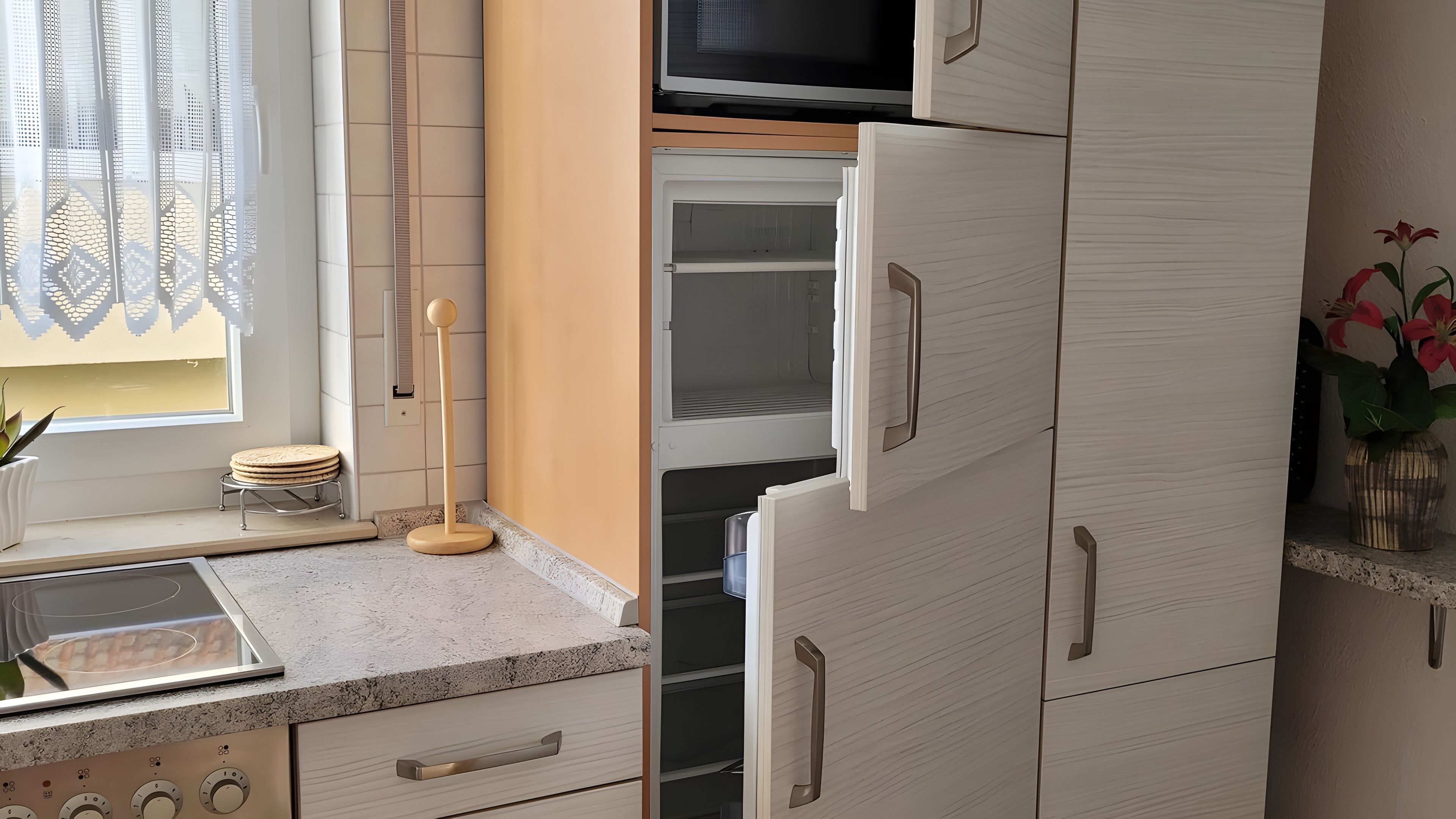 Eine Küche mit einer Mikrowelle, einem Kühlschrank und einem Spülbecken.