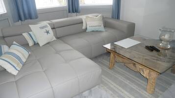 Una sala de estar moderna con un sofá gris, almohadones a rayas y una mesa de centro de madera.