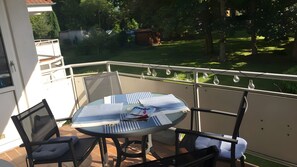 Ein runder Tisch mit Stühlen und Blick auf einen kleinen Garten.
