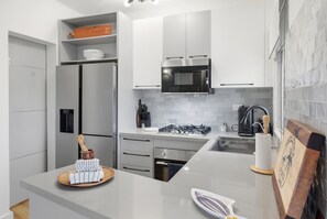 A modern kitchen with a stainless steel refrigerator, a microwave, and a gas stove. - Luxury apartment with double sea view and pool. (Punta Cana)