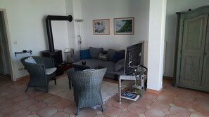 A living room with a sofa, two wicker chairs, a coffee table, a fireplace, and a cabinet. - Apartment 'Zempin Seebad, Dorfstraße 20' with Wi-Fi (Zempin (Seebad))