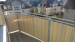 A balcony with a metal railing and a wooden fence. - Apartment 'Koserow Seebad, Waldstraße 14' with Balcony and Wi-Fi (Koserow)