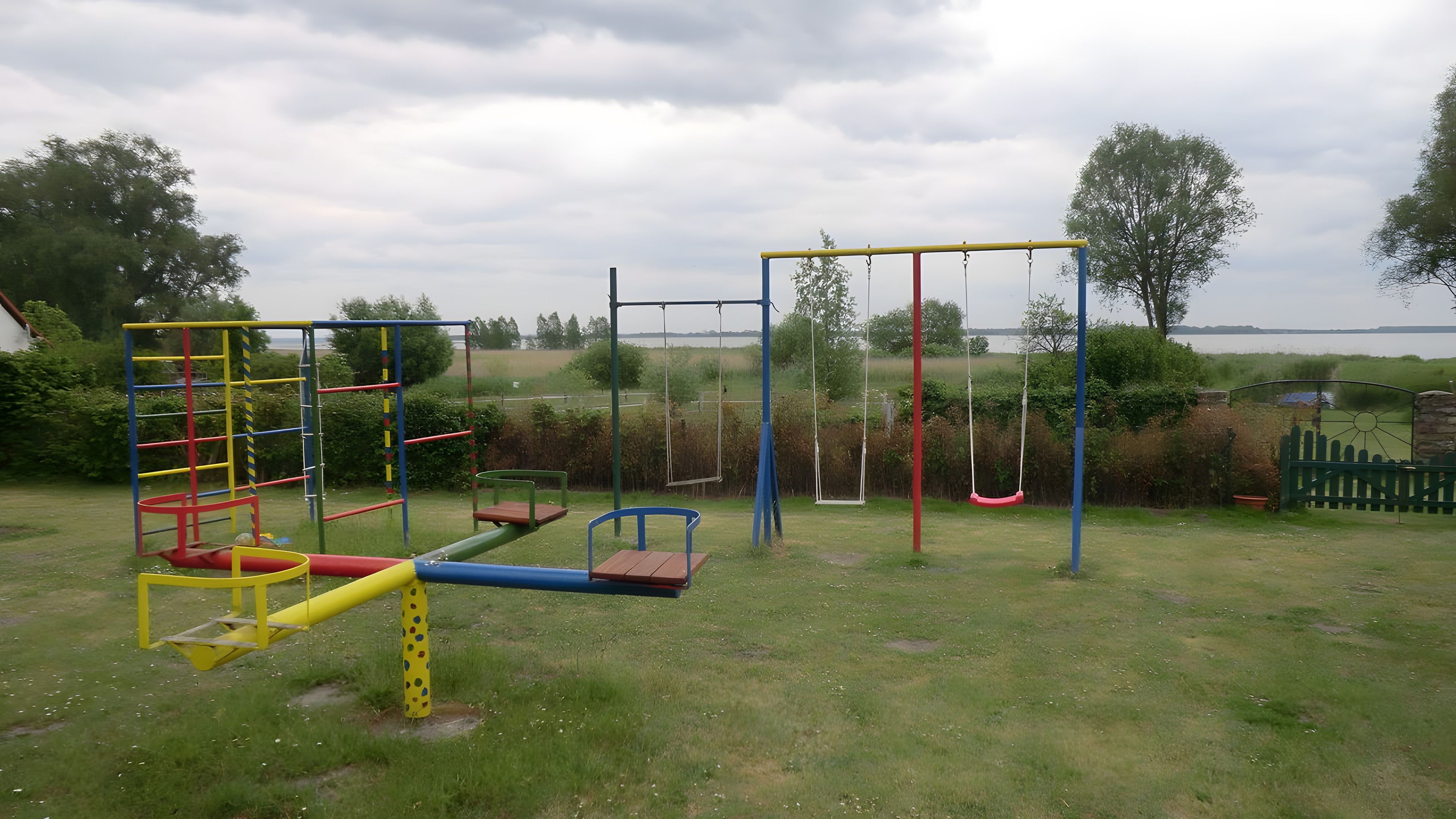 Une aire de jeux dotée de diverses installations, notamment une structure d’escalade, des balançoires et une bascule.