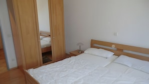 Ein Schlafzimmer mit einem Bett, einem Nachttisch und einem Kleiderschrank.
