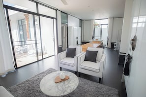 A modern living room with a marble coffee table, two white armchairs, and a grey rug. - Chalong 3bed-room seaside pool villa  (Tambon Chalong)