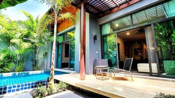 A modern house with a pool, a covered patio, and a bedroom with a large window.