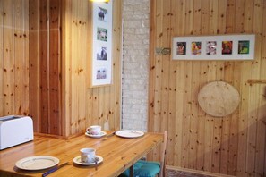 A wooden dining table with plates, cups, and a toaster. - Holiday apartment with 1 bedroom (Ostseebad Prerow)