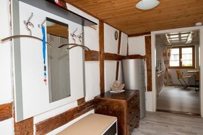 A room with a wooden ceiling, a mirror, a dresser, and a door leading to another room. - Holiday apartment with 2 bedrooms (Ermatingen)