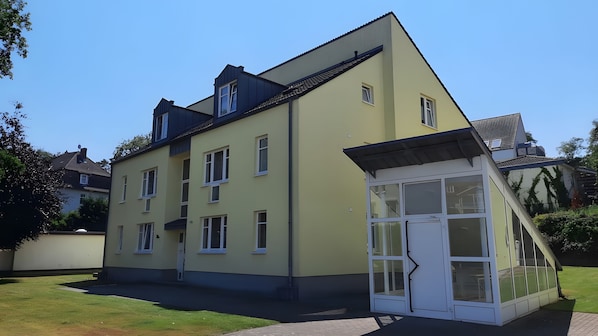 Ein zweistöckiges Gebäude mit flachem Dach und zahlreichen Fenstern.