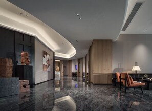 A modern lobby with a curved ceiling, marble flooring, and contemporary furniture. - Mehood Elegant Hotel  (Changsha)