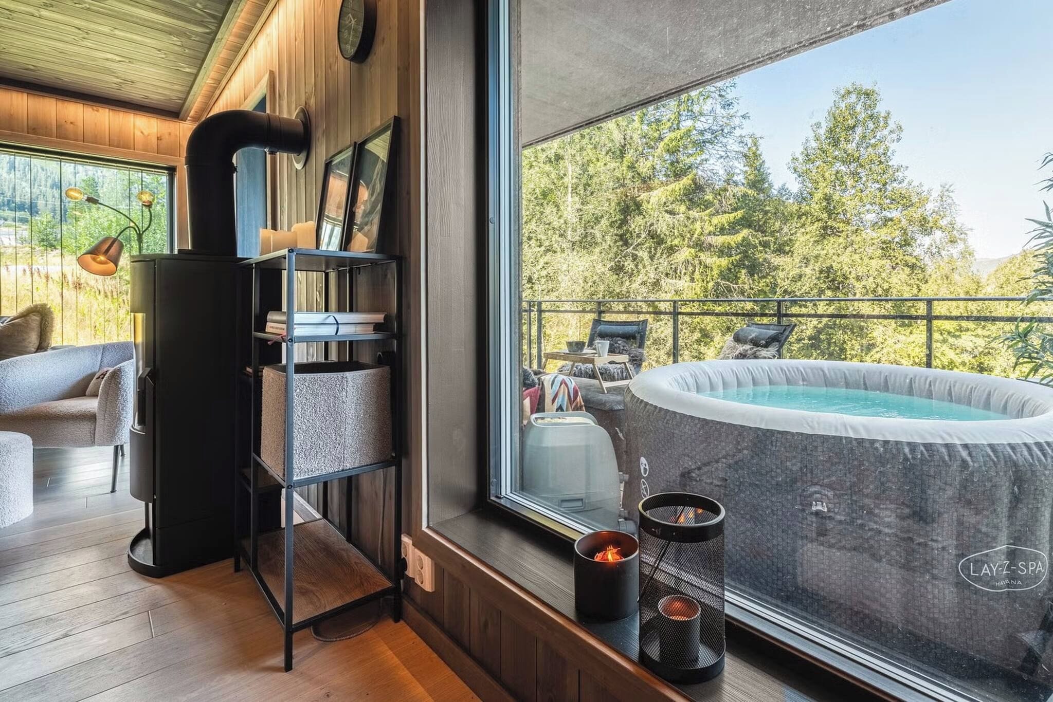 Una habitación acogedora con un amplio ventanal, un jacuzzi y una chimenea.