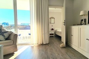 A room with a bed, a nightstand, a lamp, and a view of the outdoors. - Holiday apartment in Sylt with 2 bedrooms (Westerland\/Sylt)