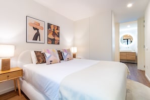 A modern bedroom with a large bed, two bedside tables, and a nightstand. There are two wall-mounted artworks above the bed. - Polacos Residence by LovelyStay (Vila Nova de Gaia)