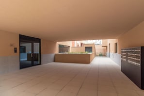 A corridor with a glass door, a planter with plants, and a mailbox. - Polacos Residence by LovelyStay (Vila Nova de Gaia)