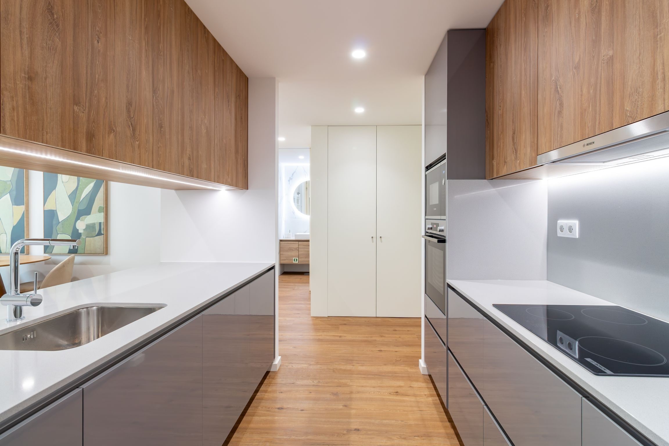Une cuisine moderne dotée d’appareils électroménagers en acier inoxydable, de meubles en bois et d’un îlot central.