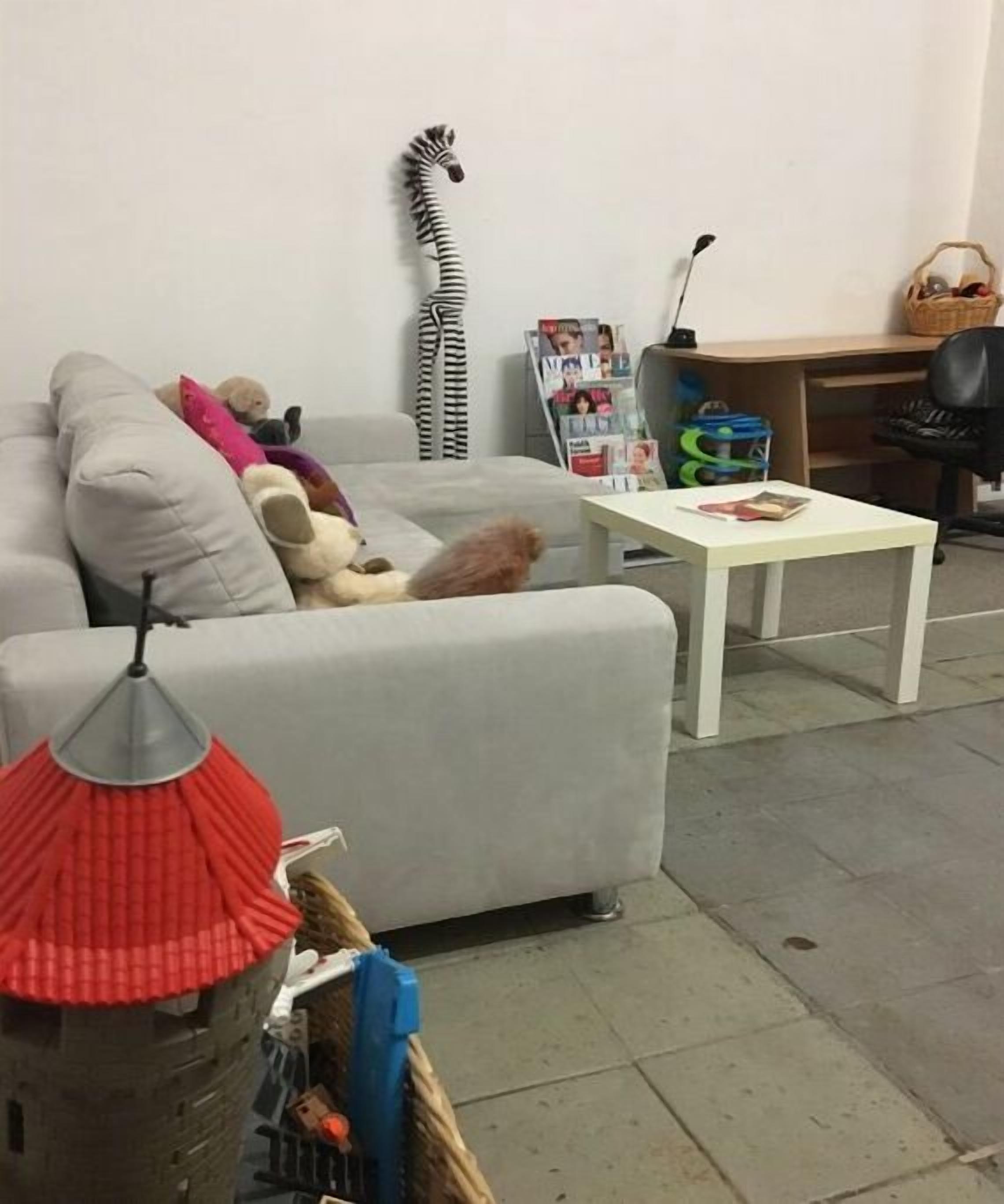 Ein Wohnzimmer mit einer Couch, einem kleinen Tisch, einer Lampe und einer Zebradeko.