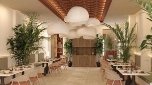 A restaurant with a long communal table, chairs, and potted plants. - Fahana Triana 54 Adults Only (LAS PALMAS DE GRAN CANARIA)