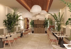Ein Restaurant mit einem langen Gemeinschaftstisch, Stühlen und Topfpflanzen.