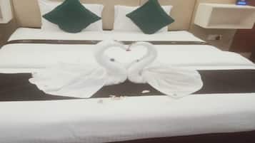 Ein Hotelzimmer mit einem Bett, Kissen und einer dekorativen Schwanen-Handtuch-Arrangement.