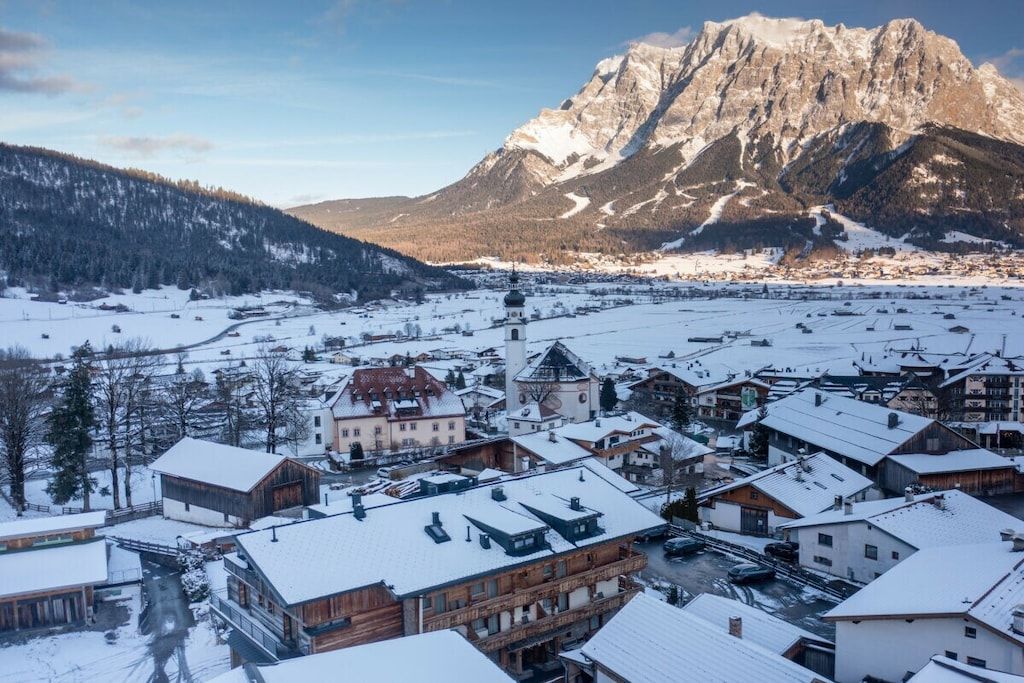 Eine verschneite Stadt mit einem markanten Berg im Hintergrund.