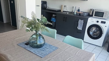 Ein Essbereich mit Tisch, Stühlen und einem Blumenstrauß.