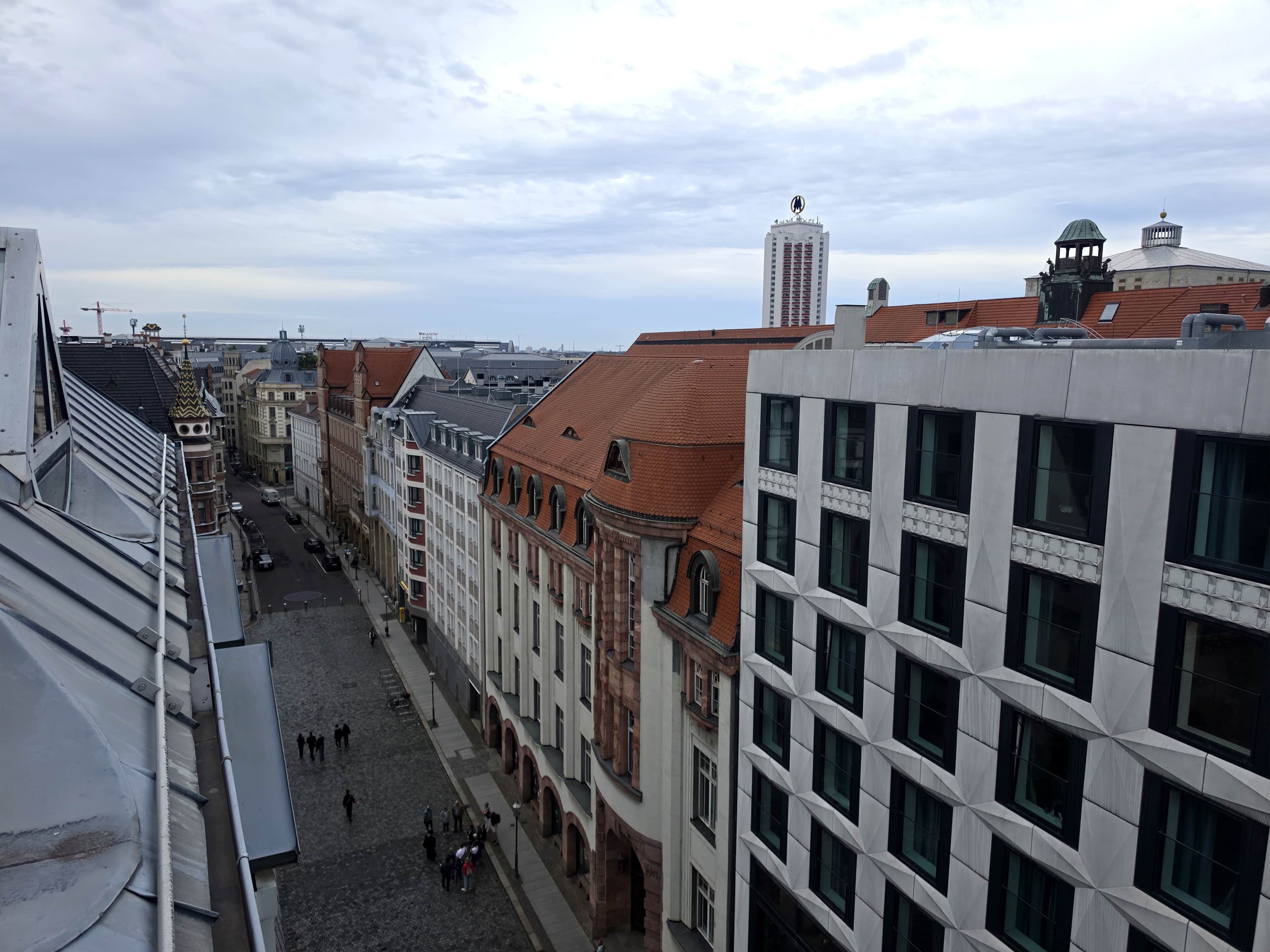 A street view with buildings, a clear sky, and a few pedestrians.