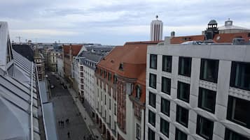 A street view with buildings, a clear sky, and a few pedestrians.