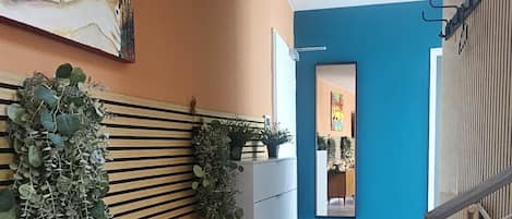 A hallway with a wooden floor, a white cabinet, and a blue wall.