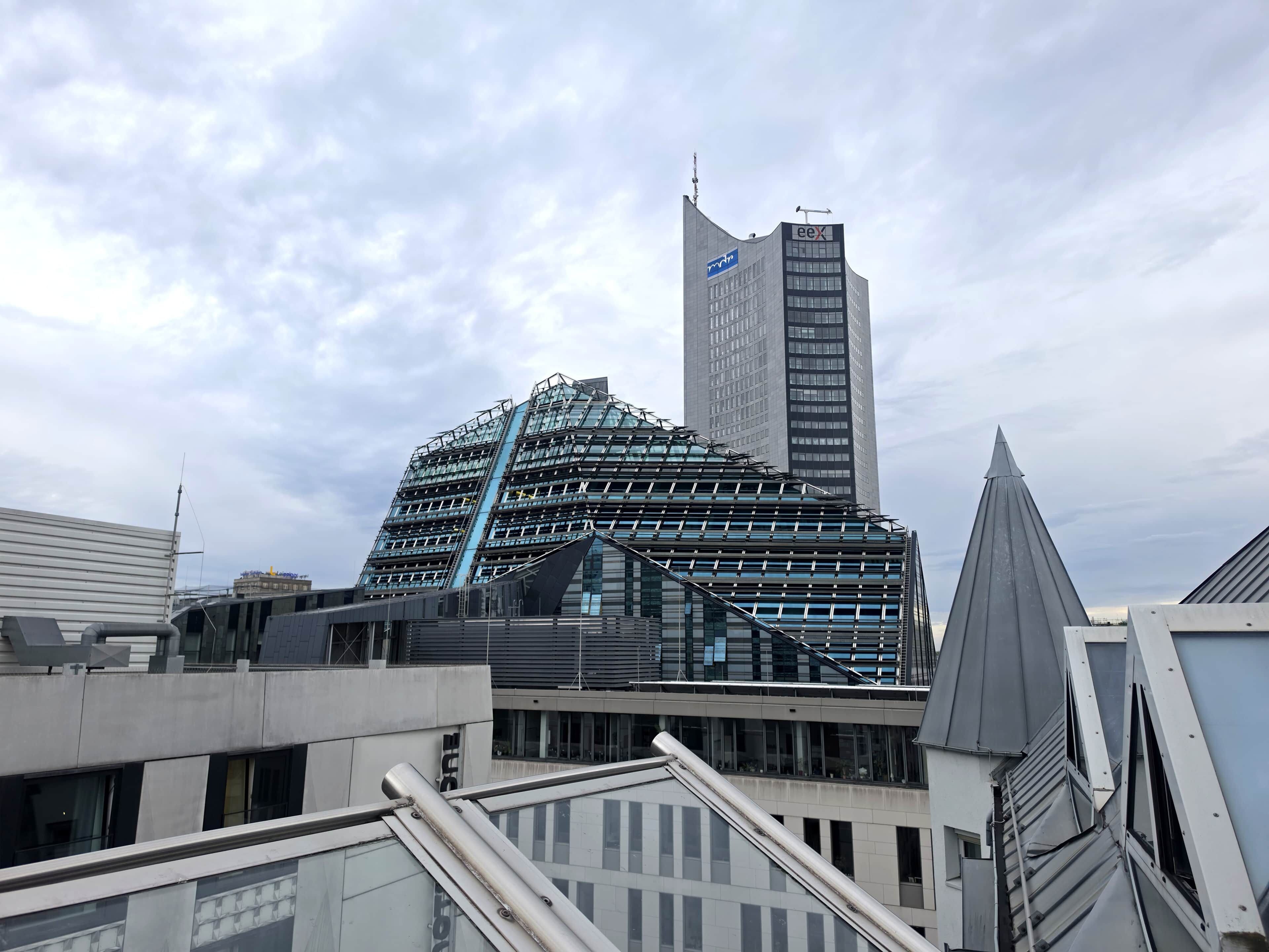 A modern building with a glass facade and a prominent 'eeX' sign on top.