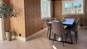 A dining area with a wooden interior, a large table, and chairs.