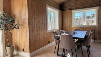 A dining area with a wooden interior, a large table, and chairs.