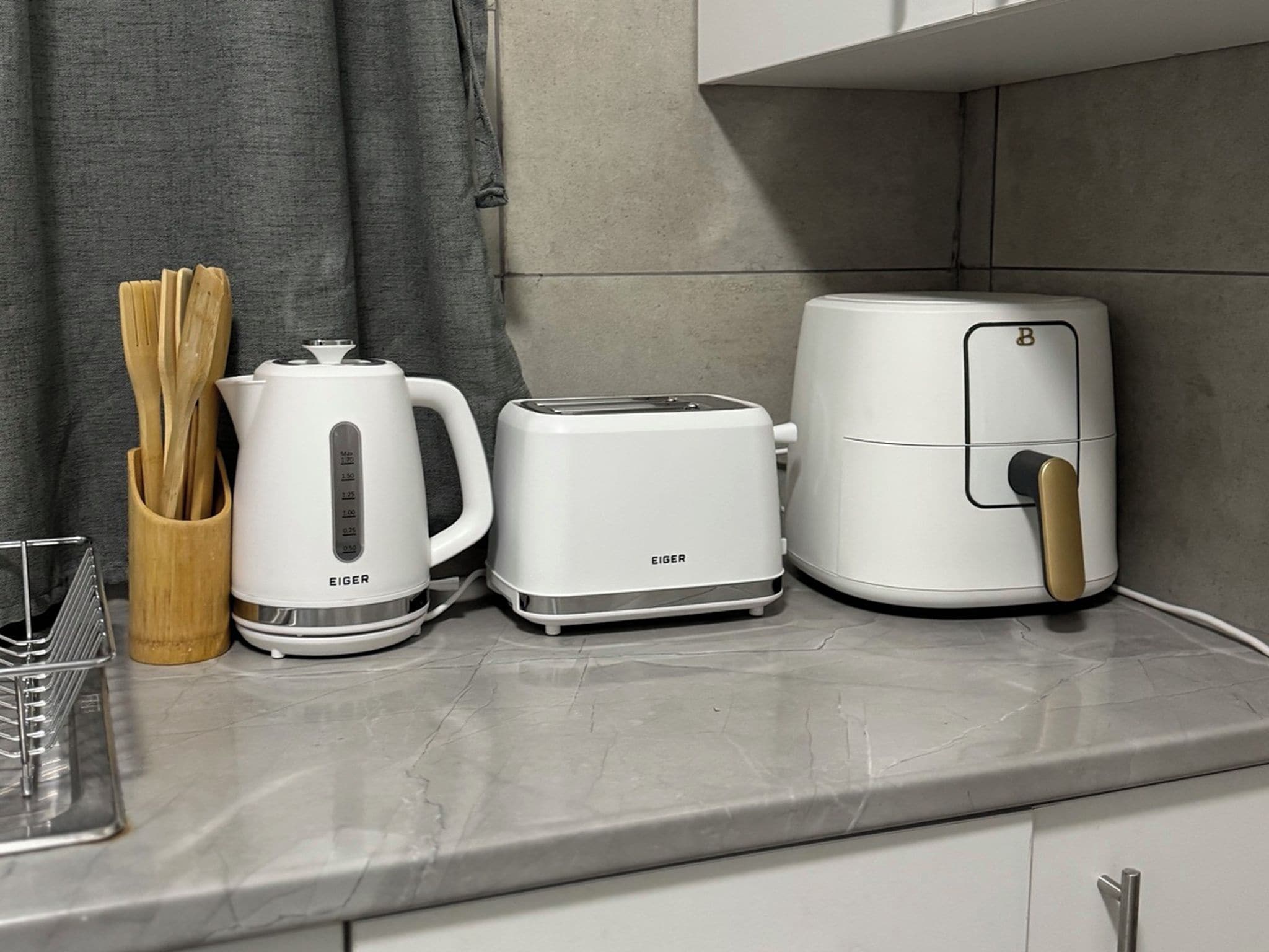 Una encimera de cocina con cafetera, tostadora y freidora de aire.