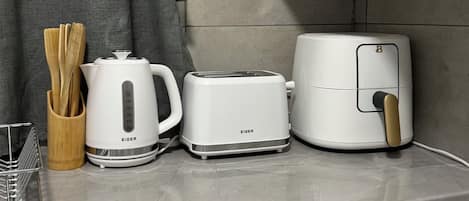 A kitchen counter with a coffee maker, toaster, and air fryer.