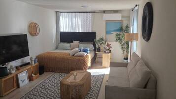 A bedroom with a bed, bedside table, lamp, and a television.