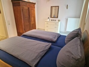 A bedroom with a bed, a dresser, a mirror, and a wardrobe. - "seahorse" House Clarinet (Nebel)