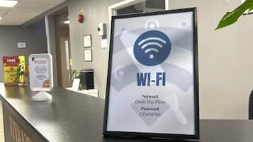 Una recepción con un cartel de Wi-Fi, la contraseña de la red para huéspedes en el piso superior y un letrero de Timra al fondo.